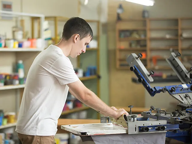 In house design expert carefully imprinting custom logo onto a eco-friendly bag